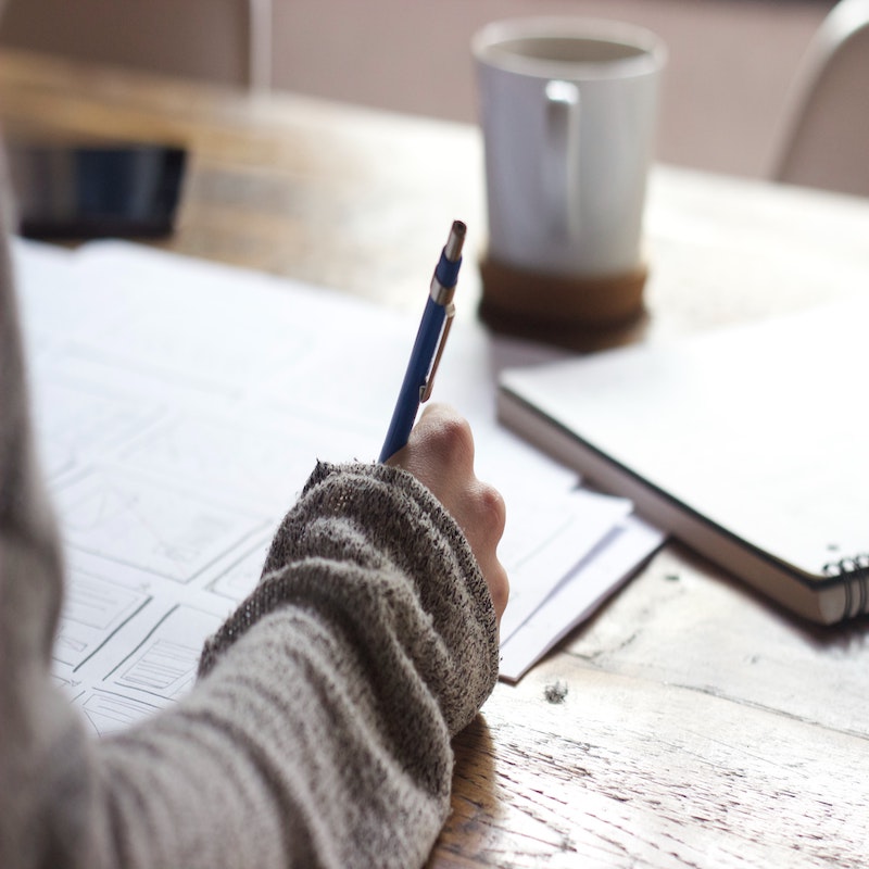 Image of person writing on paper.